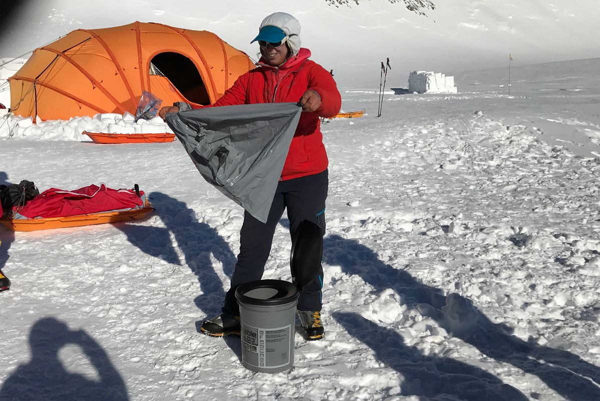 04B Guide Pachi Demonstrating How To Place The Wag Bag In The Toilet Bucket At Mount Vinson Low Camp